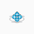The Ocean Bleu 14K White Gold Ring features four cushion-cut blue topaz gemstones in a floral design, accented by a round diamond at the center.