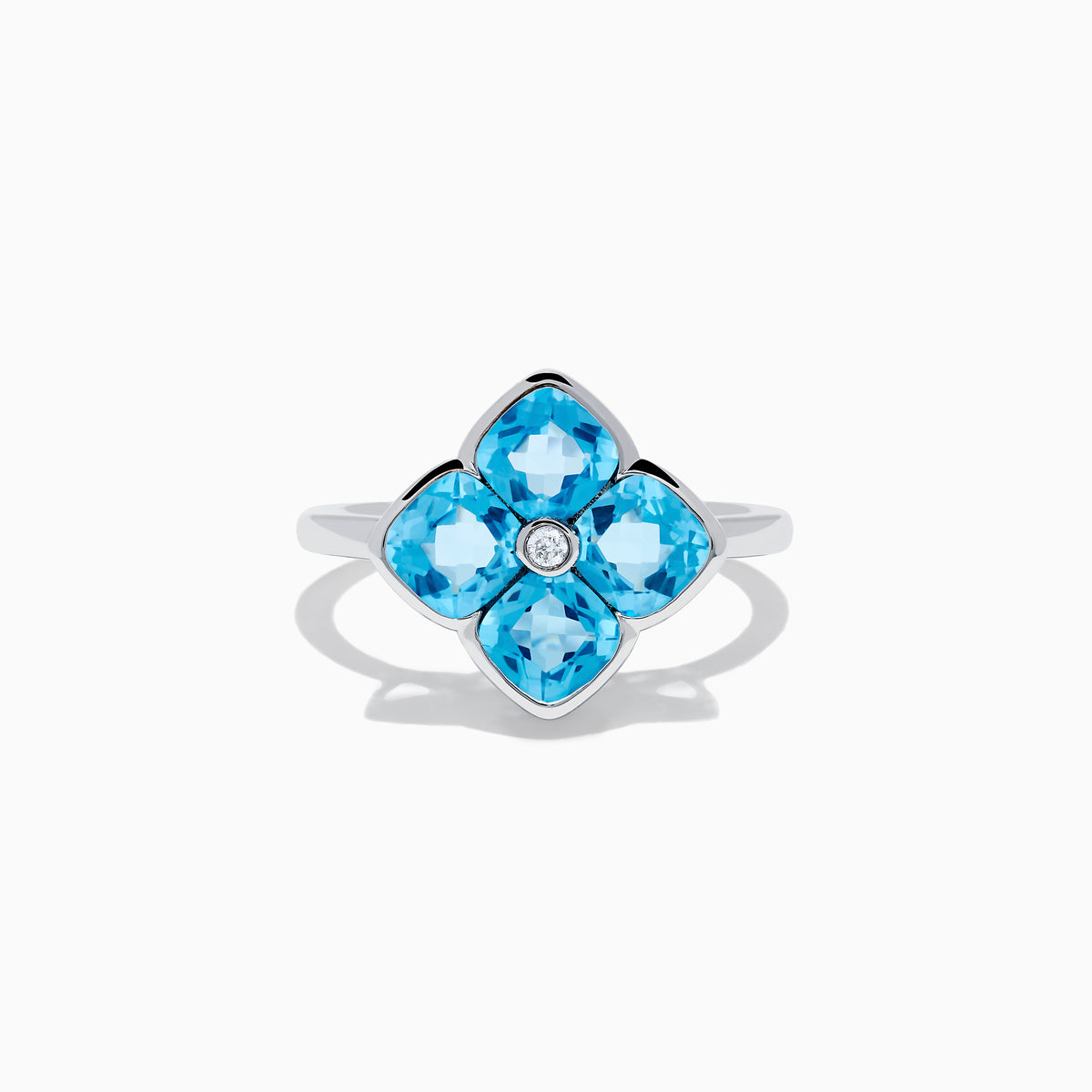 The Ocean Bleu 14K White Gold Ring features four cushion-cut blue topaz gemstones in a floral design, accented by a round diamond at the center.