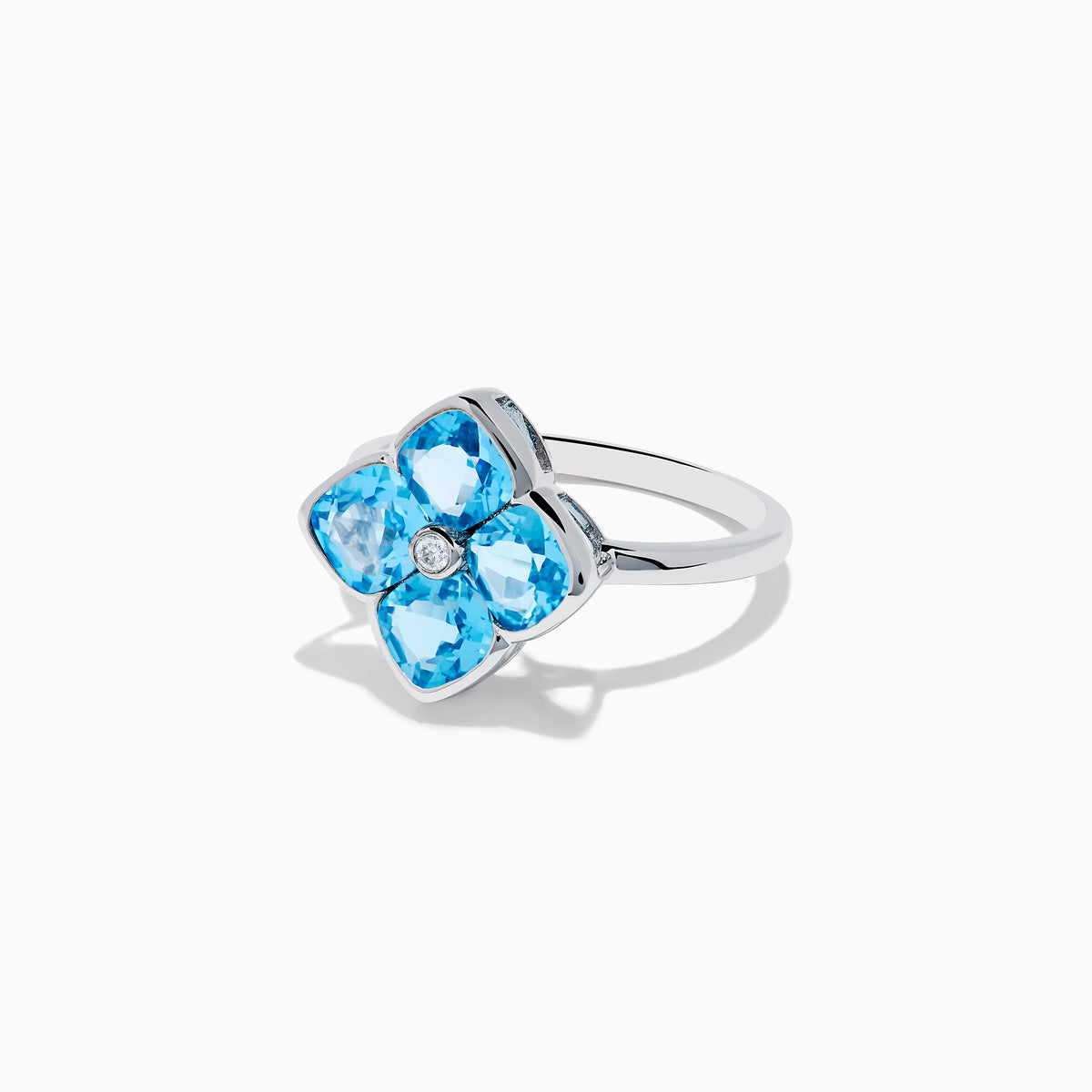 The Ocean Bleu 14K White Gold Ring features four cushion-cut blue topaz gemstones in a floral design, accented by a round diamond at the center.
