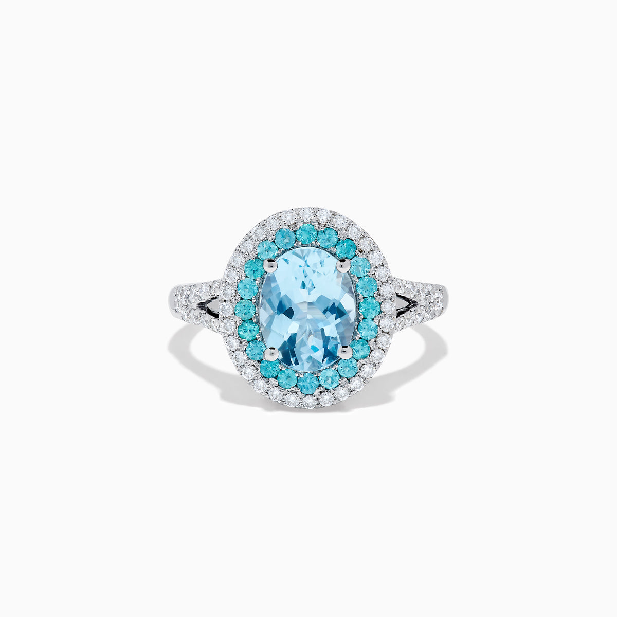 The Aquarius 14K White Gold Aquamarine, Paraiba, and Diamond Ring features an oval aquamarine center stone encircled by two halos of sparkling blue Paraiba and clear diamonds, displayed on a plain white background.