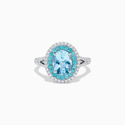 The Aquarius 14K White Gold Aquamarine, Paraiba, and Diamond Ring features an oval aquamarine center stone encircled by two halos of sparkling blue Paraiba and clear diamonds, displayed on a plain white background.