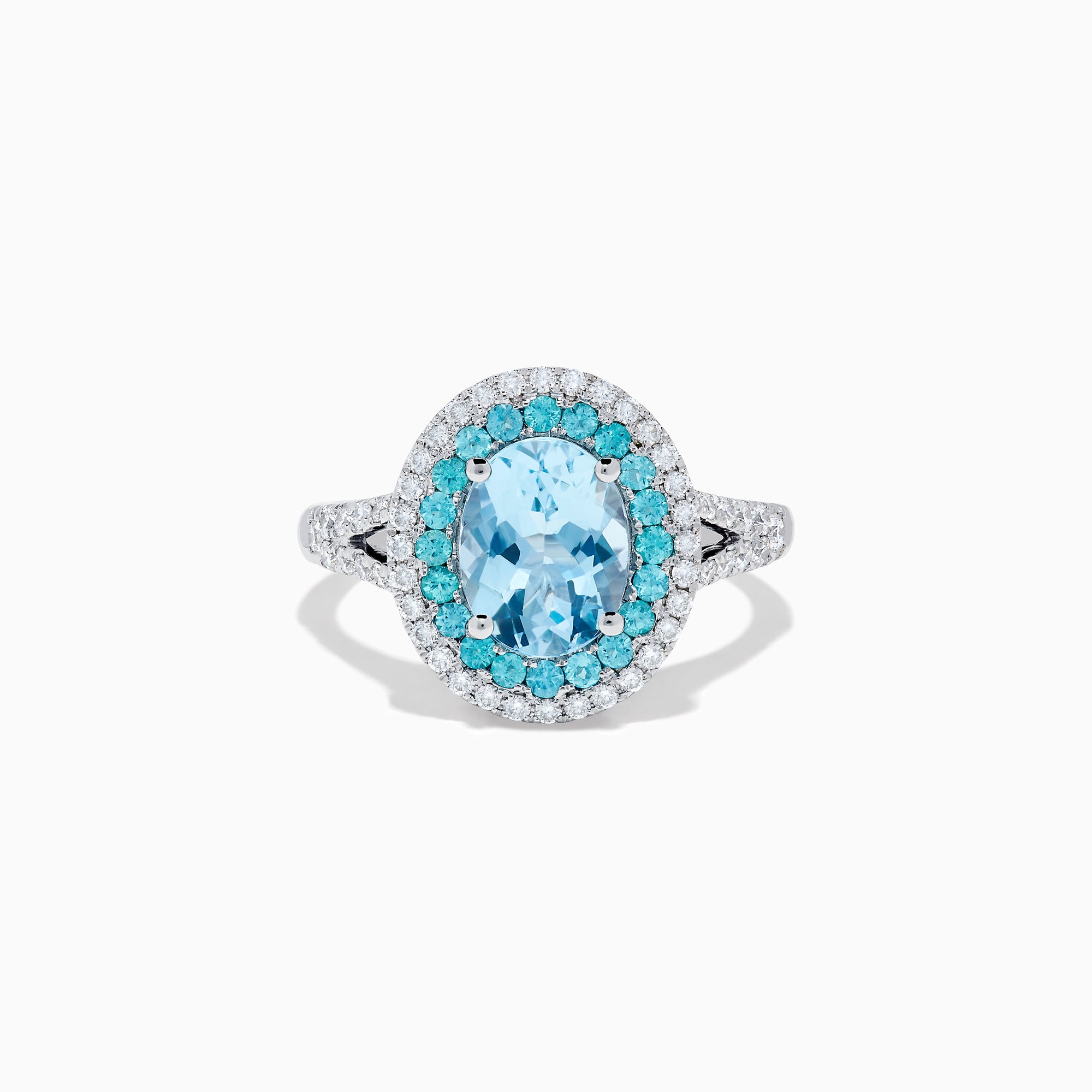 The Aquarius 14K White Gold Aquamarine, Paraiba, and Diamond Ring features an oval aquamarine center stone encircled by two halos of sparkling blue Paraiba and clear diamonds, displayed on a plain white background.
