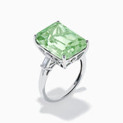 A 14K White Gold Green Amethyst and Diamond 3-Stone Ring features a rectangular, faceted green amethyst center with two small side diamonds, set in white gold and displayed against a white background.