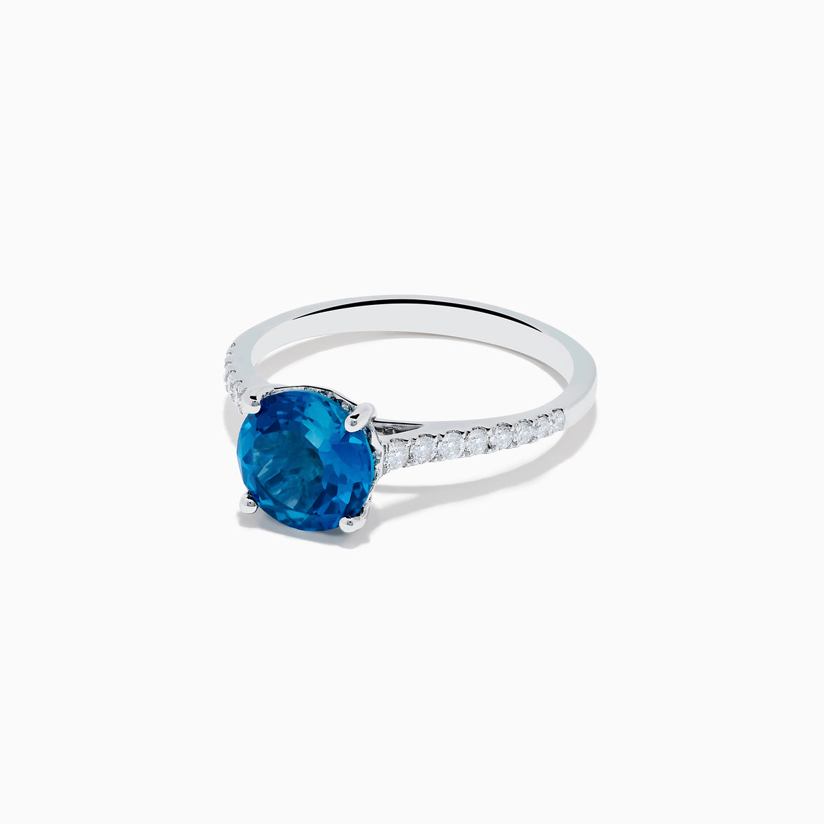 The 14K White Gold London Blue Topaz and Diamond Ring features a round blue topaz center and small diamonds along the band, showcased on a white background.