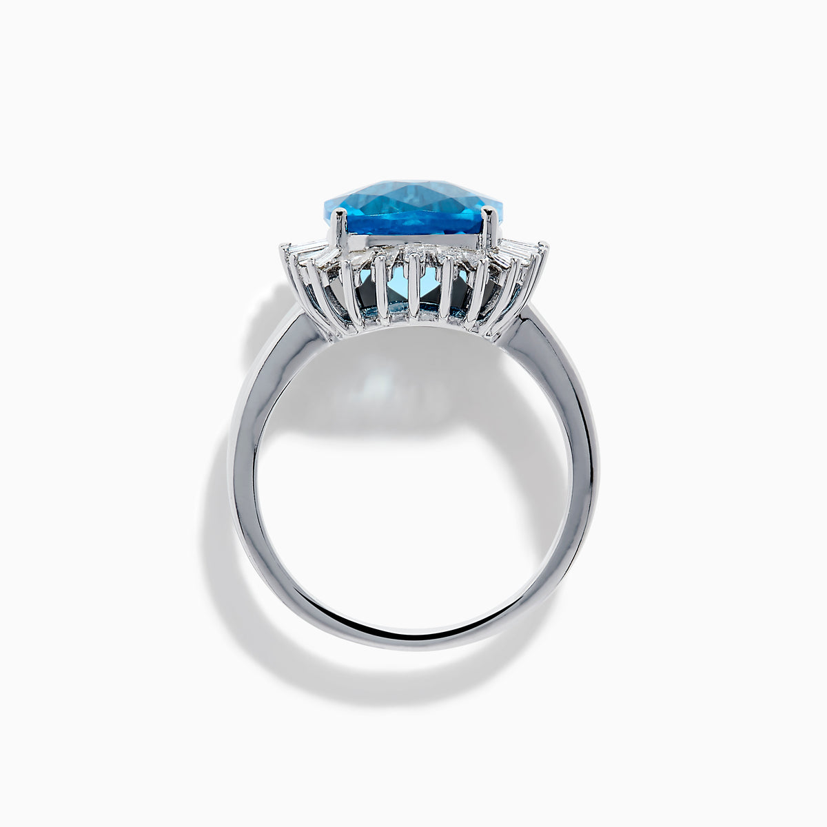 The Ocean Bleu 14K White Gold Blue Topaz and Diamond Halo Ring features a large cushion-cut blue topaz center stone, surrounded by a sparkling halo of baguette-shaped diamonds, all set in elegant white gold.