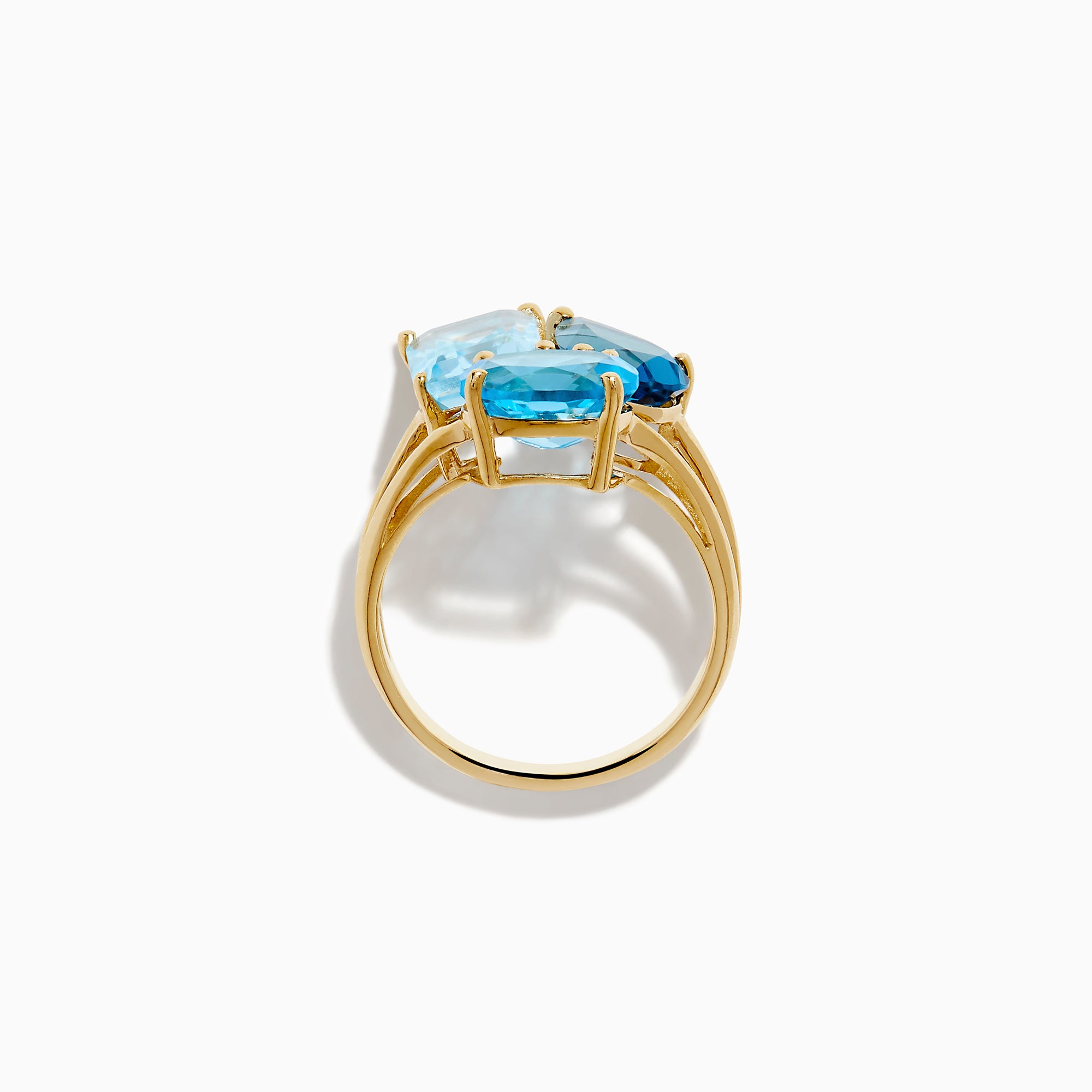 The 14K Yellow Gold London, Swiss & Sky Blue Cocktail Ring features three asymmetrically-clustered gemstones: an oval light blue, a round Swiss blue, and a rectangular light blue stone.