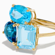 The 14K Yellow Gold London, Swiss & Sky Blue Cocktail Ring features three asymmetrically-clustered gemstones: an oval light blue, a round Swiss blue, and a rectangular light blue stone.