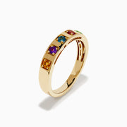 The 14K Yellow Gold Multi Colored Gemstone Band features five square gemstones—orange, purple, blue, red, and green—set in a vibrant row across the yellow gold band.
