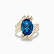 The Ocean Bleu 14K Yellow Gold London Blue Topaz and Diamond Ring showcases a large, oval London Blue Topaz center with sparkling diamond rows in a wavy, geometric design.
