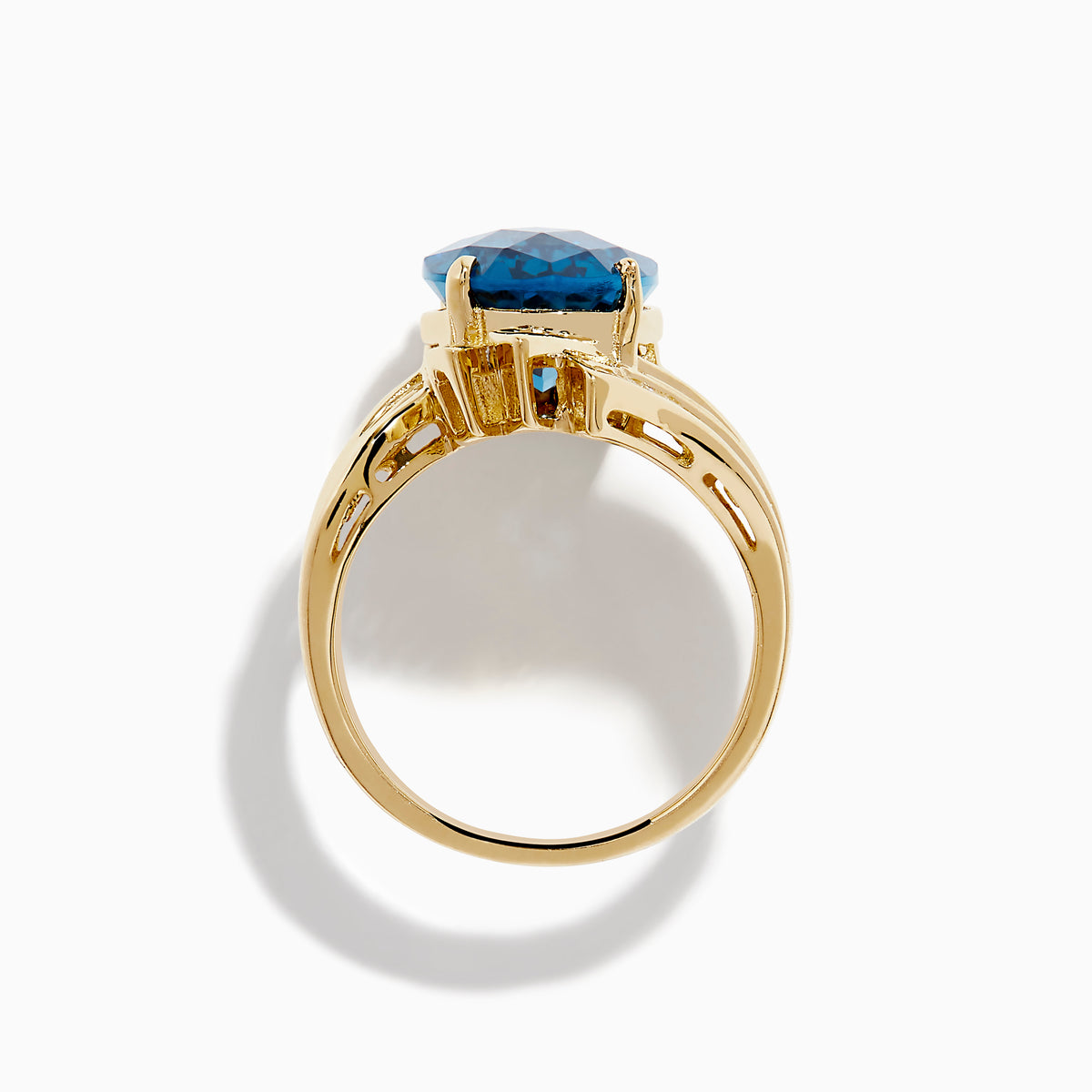 The Ocean Bleu 14K Yellow Gold London Blue Topaz and Diamond Ring showcases a large, oval London Blue Topaz center with sparkling diamond rows in a wavy, geometric design.