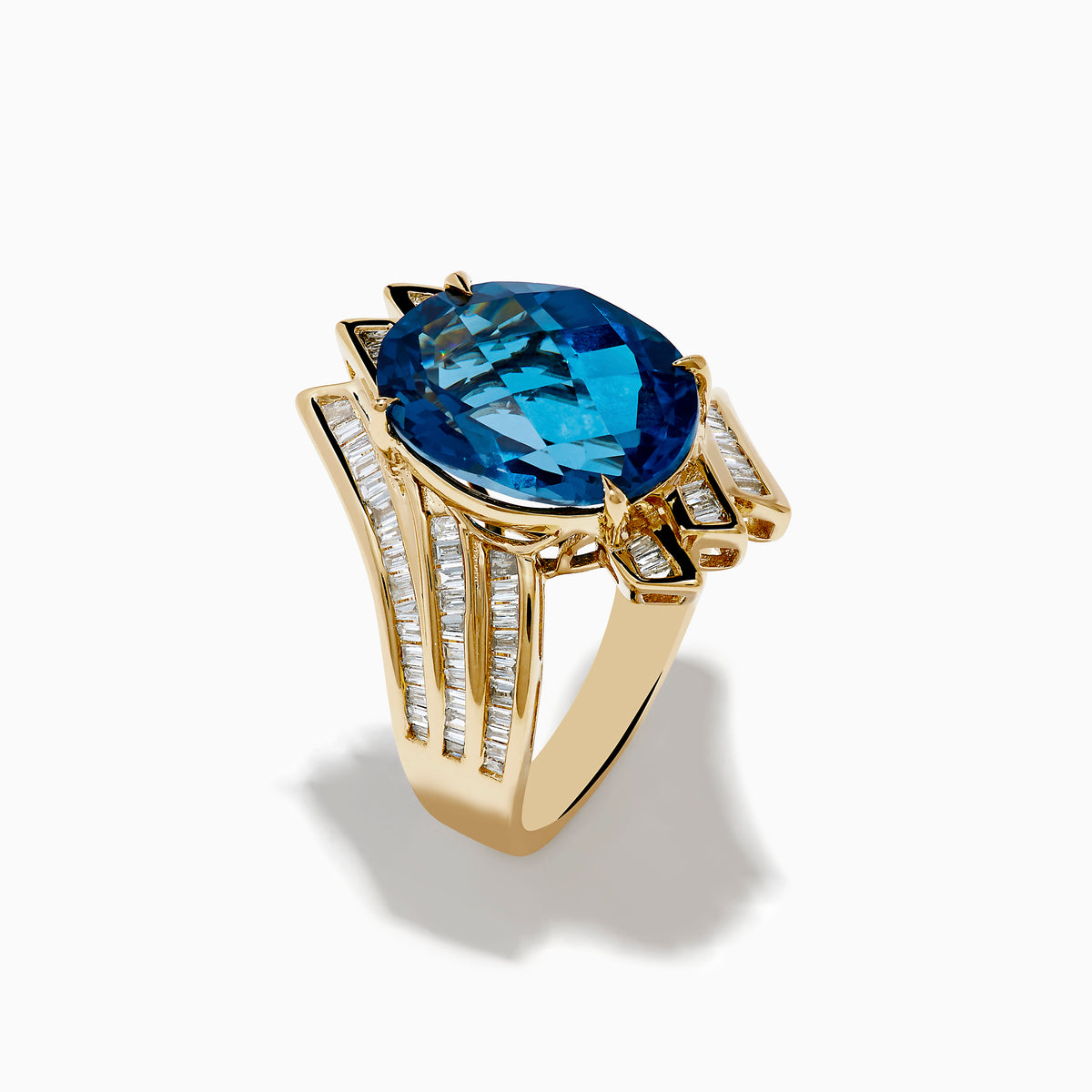 The Ocean Bleu 14K Yellow Gold London Blue Topaz and Diamond Ring showcases a large, oval London Blue Topaz center with sparkling diamond rows in a wavy, geometric design.