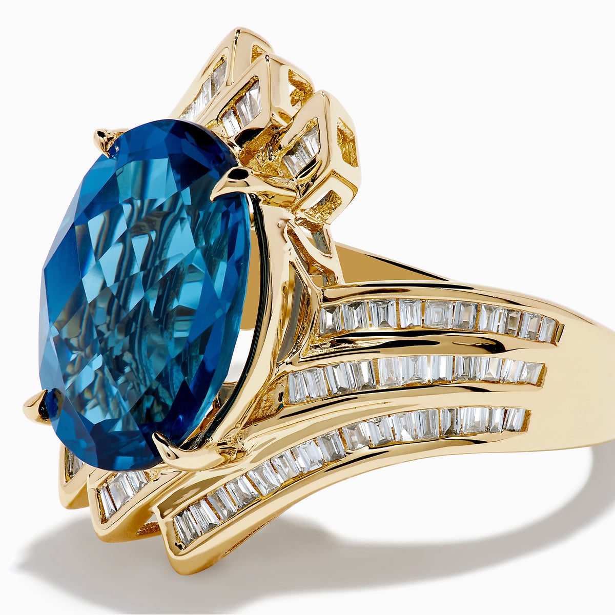 The Ocean Bleu 14K Yellow Gold London Blue Topaz and Diamond Ring showcases a large, oval London Blue Topaz center with sparkling diamond rows in a wavy, geometric design.