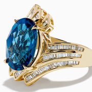 The Ocean Bleu 14K Yellow Gold London Blue Topaz and Diamond Ring showcases a large, oval London Blue Topaz center with sparkling diamond rows in a wavy, geometric design.