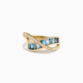 The Ocean Blue 14K Yellow Gold Blue Topaz and Diamond Criss Cross Ring features an infinity design: one band set with white diamonds, the other with rectangular blue topaz gemstones, shown on a white background.