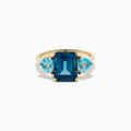 The 14K Yellow Gold Sky Blue and London Blue Topaz 3 Stone Ring features a large rectangular blue topaz flanked by two heart-shaped stones, all set in yellow gold. A stunning piece for any occasion.