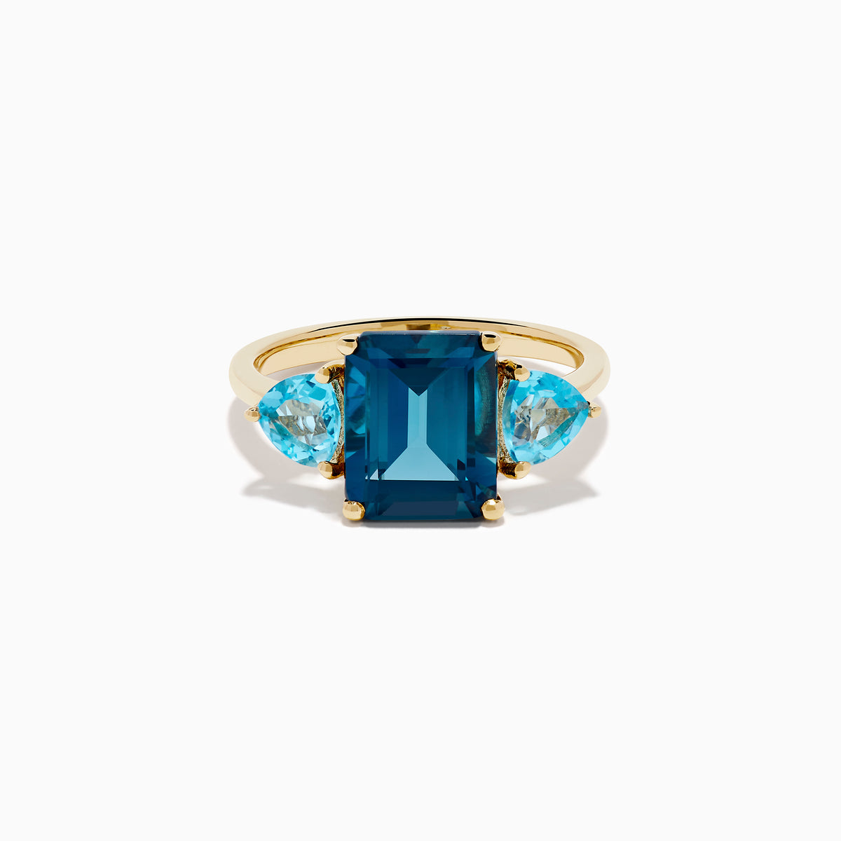 The 14K Yellow Gold Sky Blue and London Blue Topaz 3 Stone Ring features a large rectangular blue topaz flanked by two heart-shaped stones, all set in yellow gold. A stunning piece for any occasion.