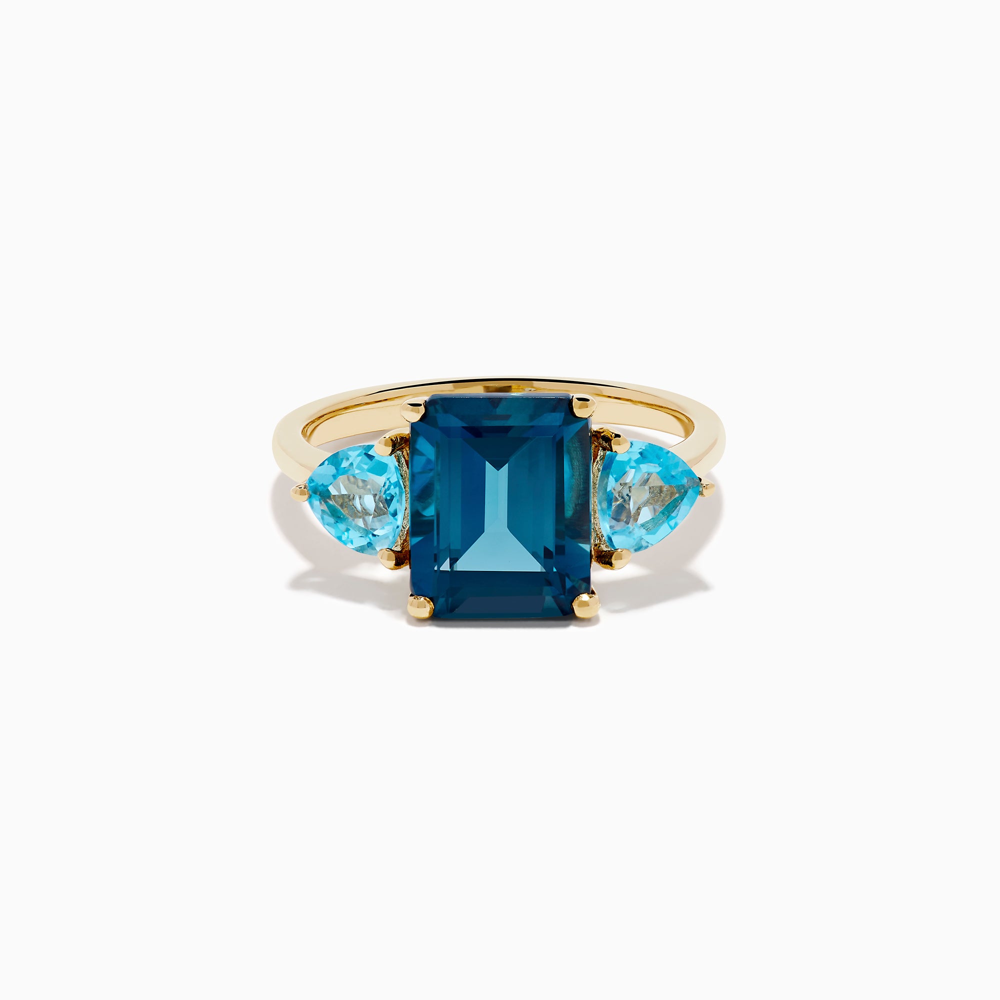 The 14K Yellow Gold Sky Blue and London Blue Topaz 3 Stone Ring features a large rectangular blue topaz flanked by two heart-shaped stones, all set in yellow gold. A stunning piece for any occasion.
