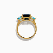The 14K Yellow Gold Sky Blue and London Blue Topaz 3 Stone Ring features a large rectangular blue topaz flanked by two heart-shaped stones, all set in yellow gold. A stunning piece for any occasion.