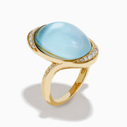 A 14K yellow gold ring featuring a sky blue topaz and mother of pearl doublet, accented with small round diamonds and set against a white background.