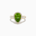 The 14K Yellow Gold Pear Shaped Peridot and Diamond Cocktail Ring features a pear-cut peridot center, a halo of white diamonds, and baguette-cut diamonds along the band for a dazzling, elegant look.