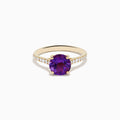 The 14K Yellow Gold Amethyst and Diamond Ring showcases a large round amethyst center accented with small white diamonds along the band, displayed on a white background.