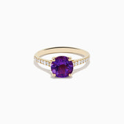 The 14K Yellow Gold Amethyst and Diamond Ring showcases a large round amethyst center accented with small white diamonds along the band, displayed on a white background.