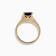 The 14K Yellow Gold Garnet and Diamond Ring features a large round deep red garnet center, accented by small white diamonds on each side of the band, displayed against a white background.