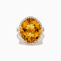 The Sunset 14K Yellow Gold Citrine and Diamond Halo Ring features a large oval citrine surrounded by sparkling diamonds, beautifully set against a plain white background.