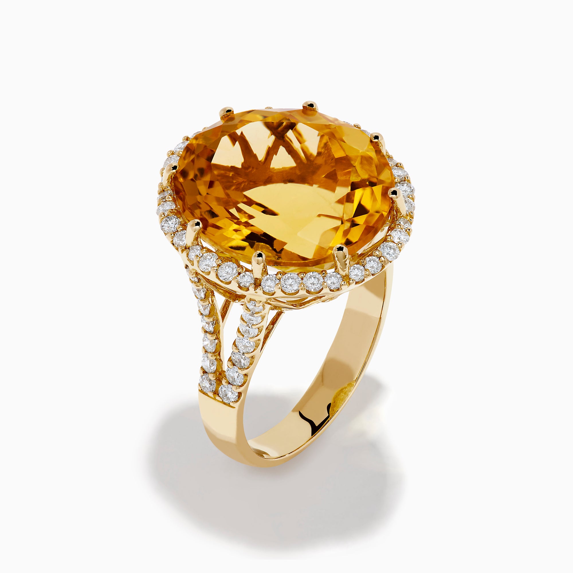 The Sunset 14K Yellow Gold Citrine and Diamond Halo Ring features a large oval citrine surrounded by sparkling diamonds, beautifully set against a plain white background.