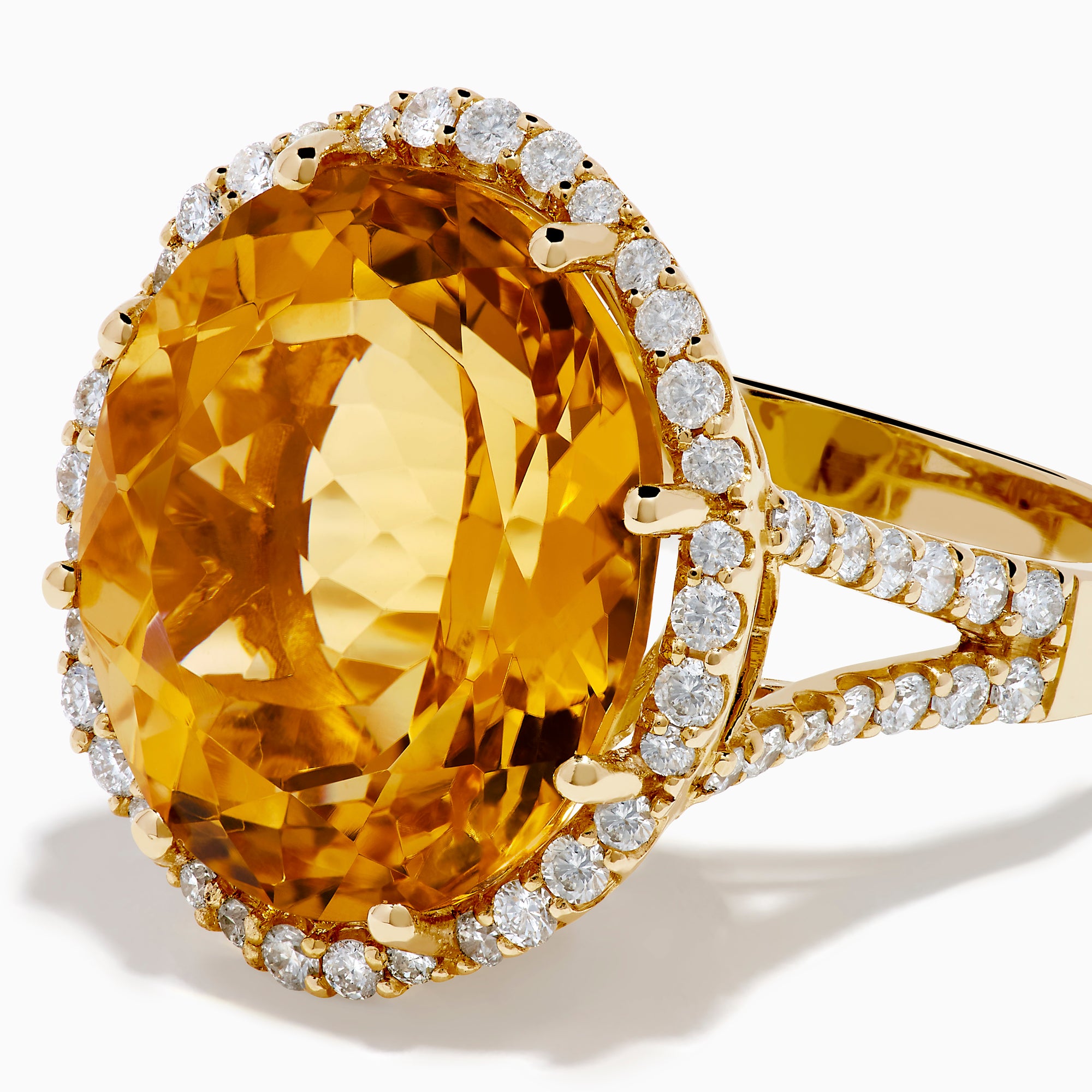The Sunset 14K Yellow Gold Citrine and Diamond Halo Ring features a large oval citrine surrounded by sparkling diamonds, beautifully set against a plain white background.