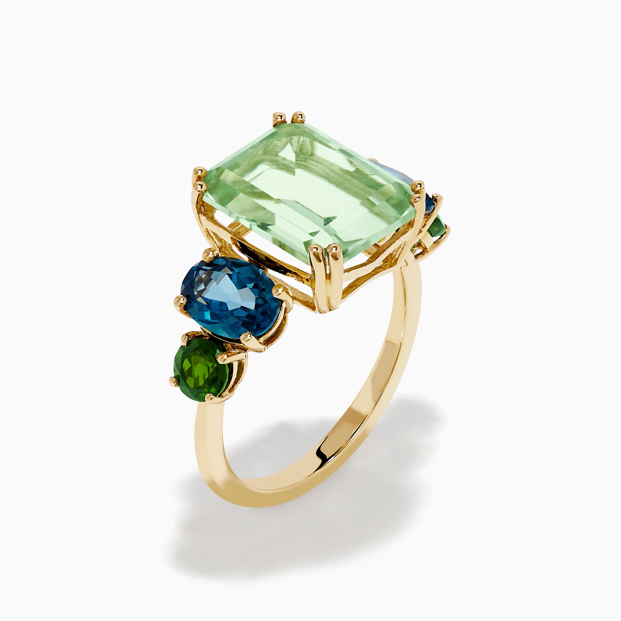 The 14K Yellow Gold Amethyst, Blue Topaz, and Chrome Diopside Cocktail Ring features a large rectangular amethyst center stone, flanked by two oval blue topaz and two smaller chrome diopside stones on each side.