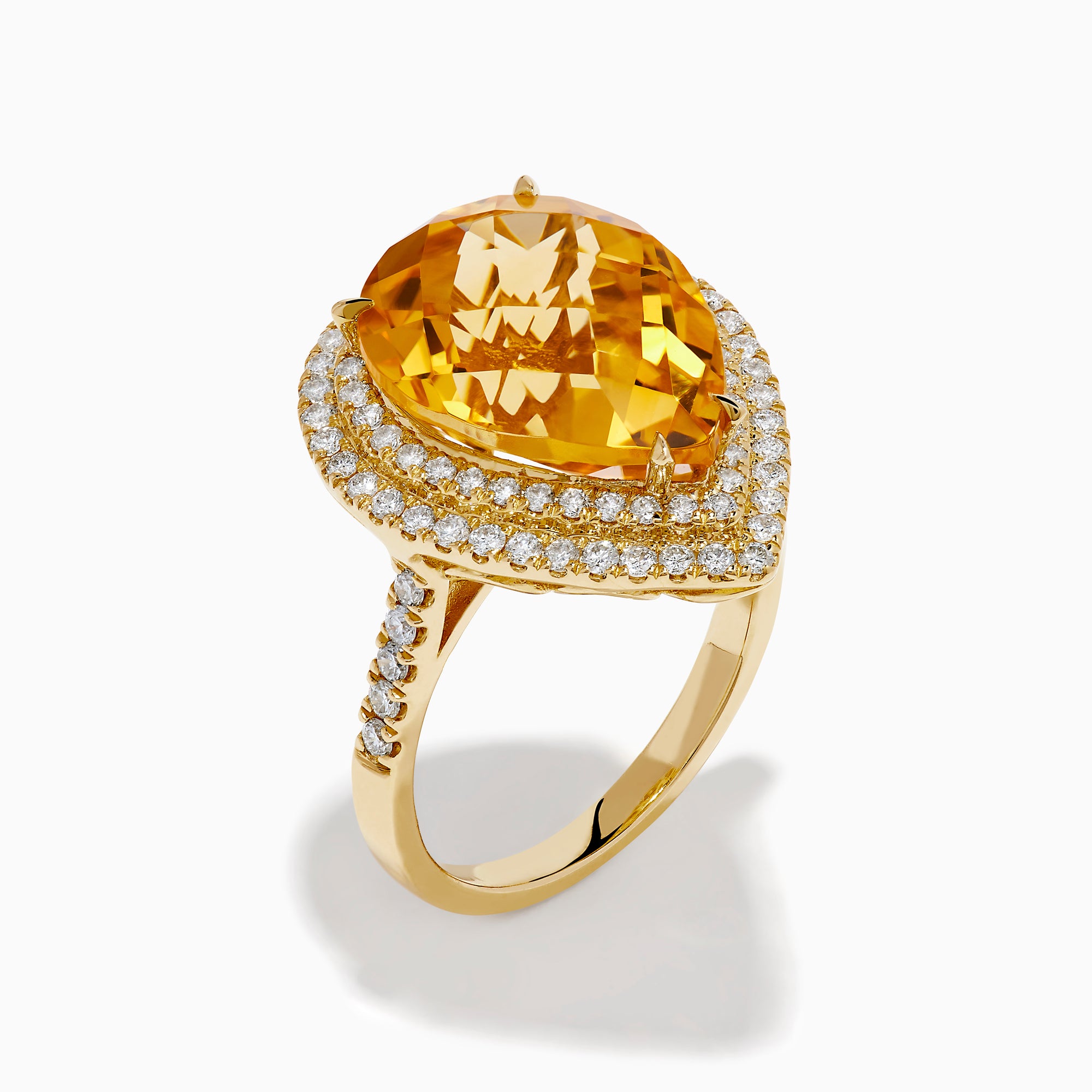 The 14K Yellow Gold Citrine and Diamond Pear Halo Cocktail Ring features a large pear-shaped citrine surrounded by a halo of round diamonds, shown on a white background.