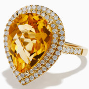 The 14K Yellow Gold Citrine and Diamond Pear Halo Cocktail Ring features a large pear-shaped citrine surrounded by a halo of round diamonds, shown on a white background.