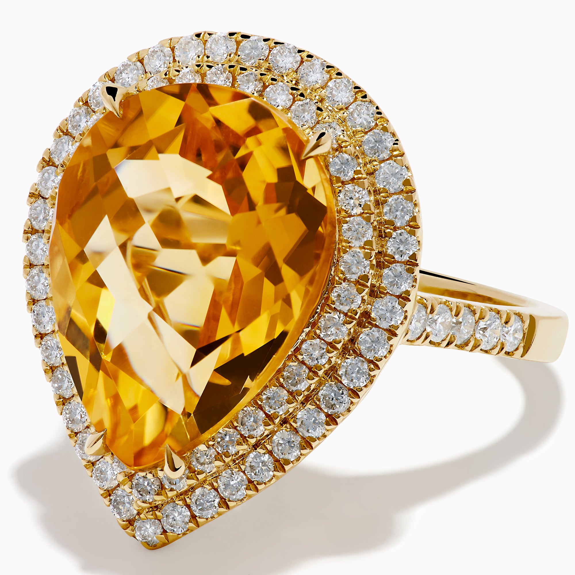 The 14K Yellow Gold Citrine and Diamond Pear Halo Cocktail Ring features a large pear-shaped citrine surrounded by a halo of round diamonds, shown on a white background.