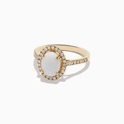 The Aurora 14K Yellow Gold Opal and Diamond Ring showcases an oval opal center, haloed by round diamonds and accented with more diamonds along its elegant band.