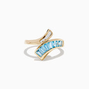 The Ocean Bleu 14K Yellow Gold Blue Topaz and Diamond Bypass Ring features sparkling white diamonds on one side and a row of rectangular blue topaz stones on the other in an elegant bypass design.