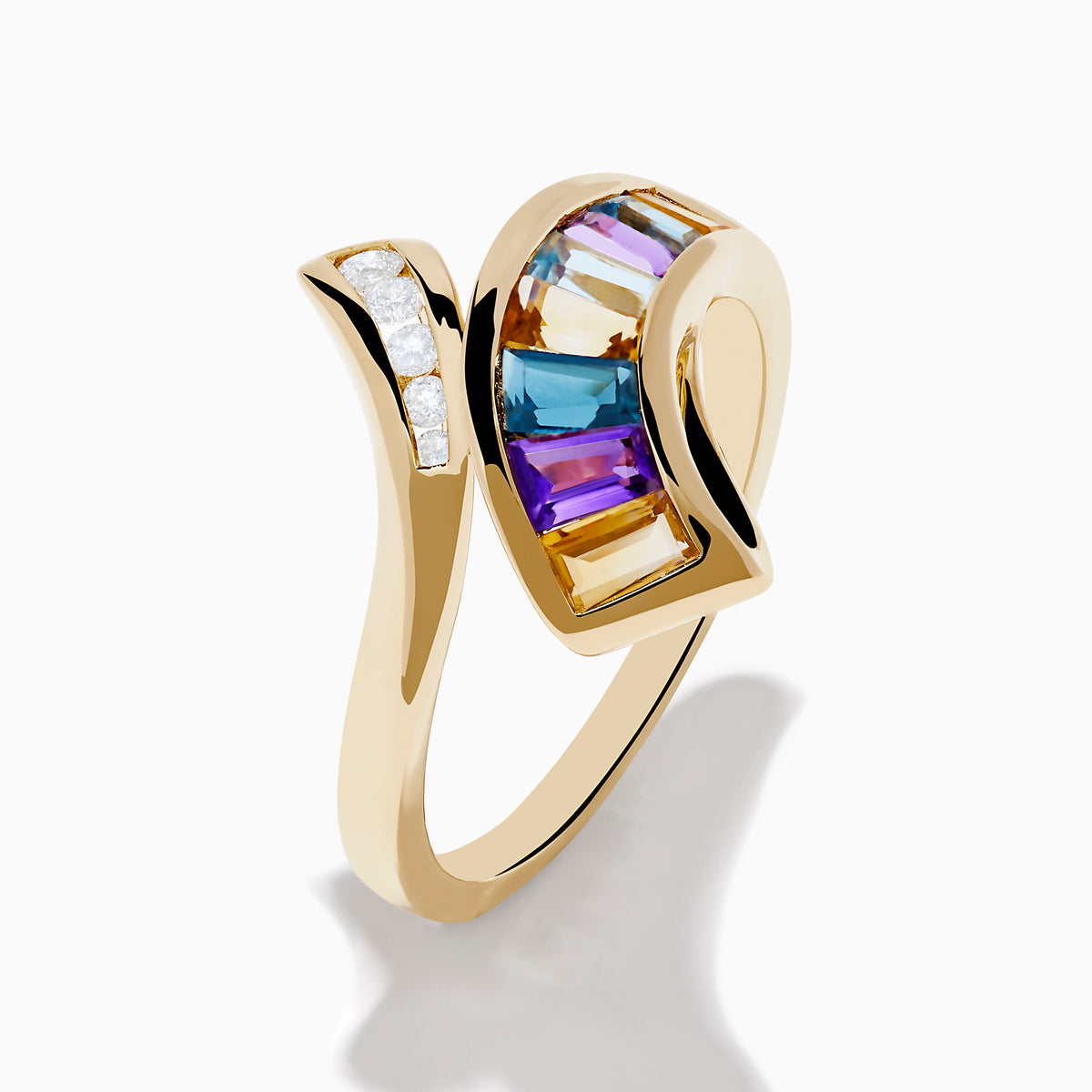 The Mosaic 14K Yellow Gold Multi Color Gemstone and Diamond Bypass Ring features asymmetrical arms set with white diamonds and rectangular multi color gemstones, shown on a white background.