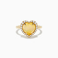 The Aurora 14K Yellow Gold Opal and Diamond Heart Halo Ring features a heart-shaped opal at the center, surrounded by a diamond halo.