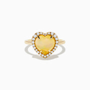 The Aurora 14K Yellow Gold Opal and Diamond Heart Halo Ring features a heart-shaped opal at the center, surrounded by a diamond halo.