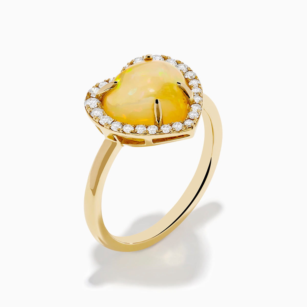 The Aurora 14K Yellow Gold Opal and Diamond Heart Halo Ring features a heart-shaped opal at the center, surrounded by a diamond halo.