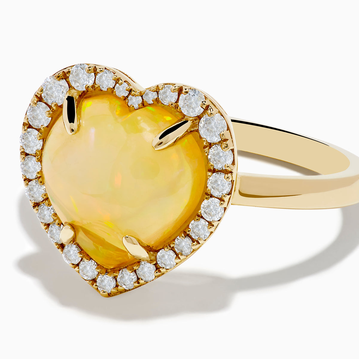 The Aurora 14K Yellow Gold Opal and Diamond Heart Halo Ring features a heart-shaped opal at the center, surrounded by a diamond halo.