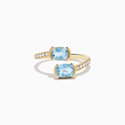 The Aquarius 14K Yellow Gold Aquamarine and Diamond Bypass Ring showcases two square-cut aquamarines facing each other, with sparkling round diamonds accenting one side of the band.