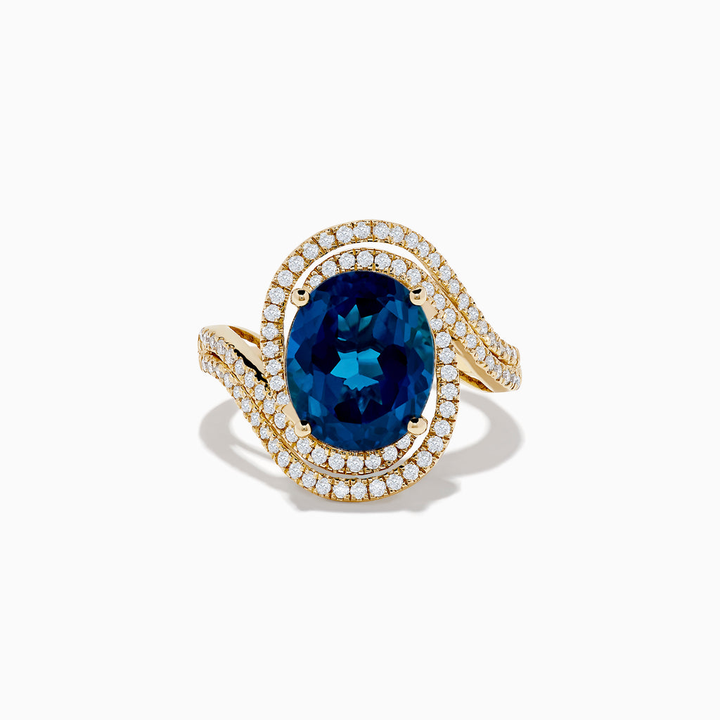 The Ocean Blue 14K Gold London Blue Topaz and Diamond Ring showcases a large oval topaz centerpiece, accented by two wavy rows of sparkling diamonds.
