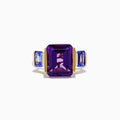 The 14K Yellow Gold Amethyst and Tanzanite 3 Stone Ring features a central emerald-cut amethyst with two rectangular tanzanites on each side, all set against a white background.