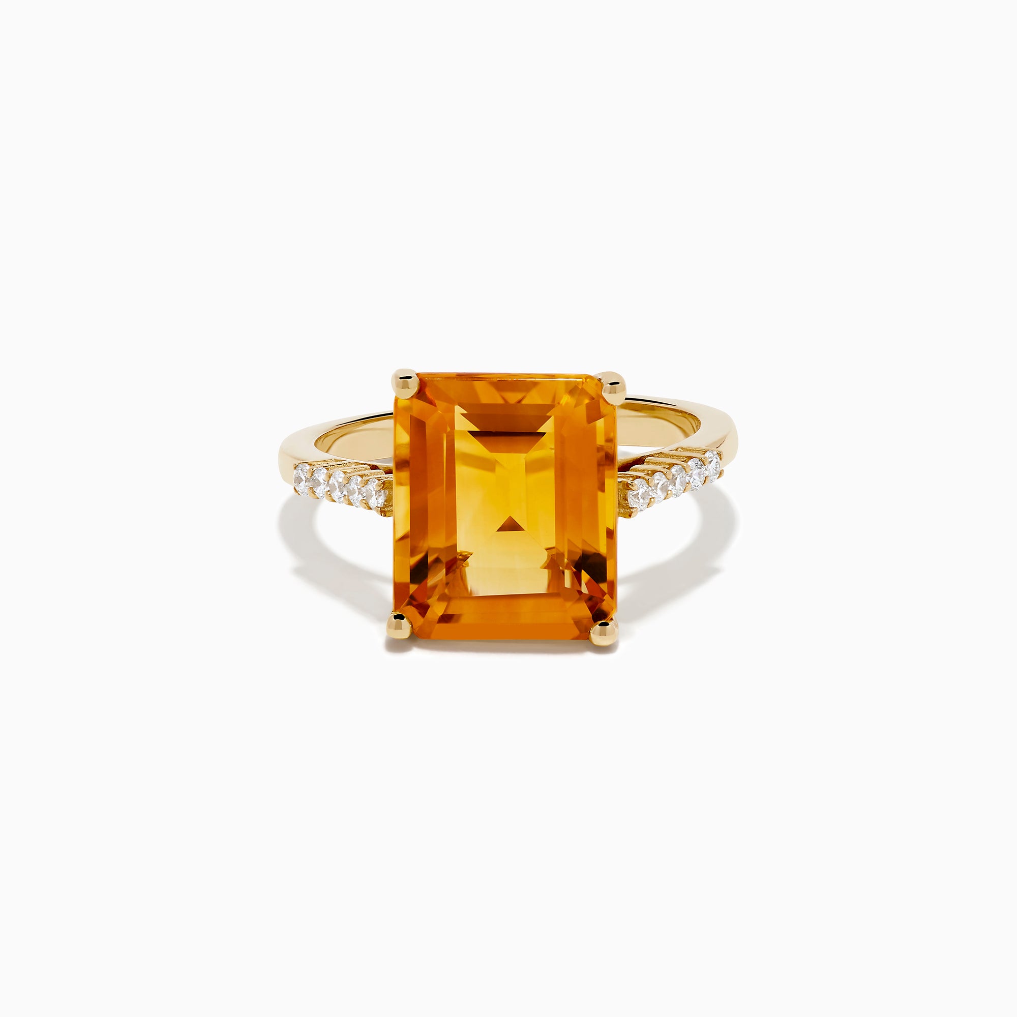 The 14K Yellow Gold Step Cut Citrine and Diamond Cocktail Ring features a large rectangular citrine centerpiece with small round diamonds set along the band on each side of the main stone.