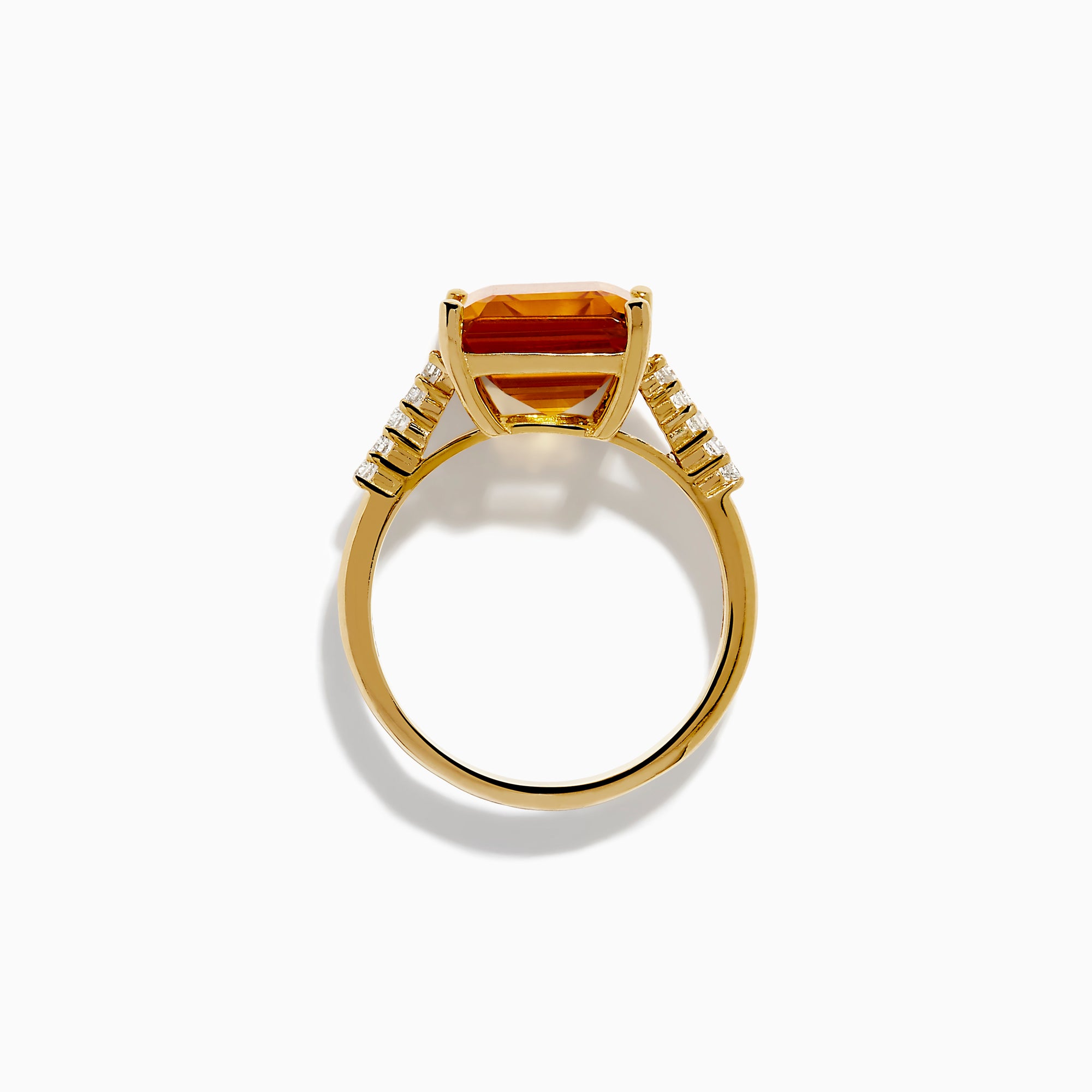 The 14K Yellow Gold Step Cut Citrine and Diamond Cocktail Ring features a large rectangular citrine centerpiece with small round diamonds set along the band on each side of the main stone.