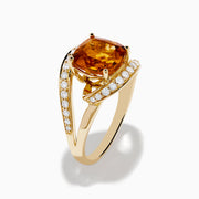The Sunset 14K Yellow Gold Citrine Diamond Ring showcases a large cushion-cut citrine center stone, accented by curved bands adorned with sparkling diamonds.