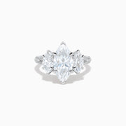 The Lab Grown Marquise Diamond 3 Stone Ring in 14K White Gold features a central marquise-cut lab grown diamond, two flanking marquise-cut diamonds, and two round diamonds set on a detailed band against a white background.