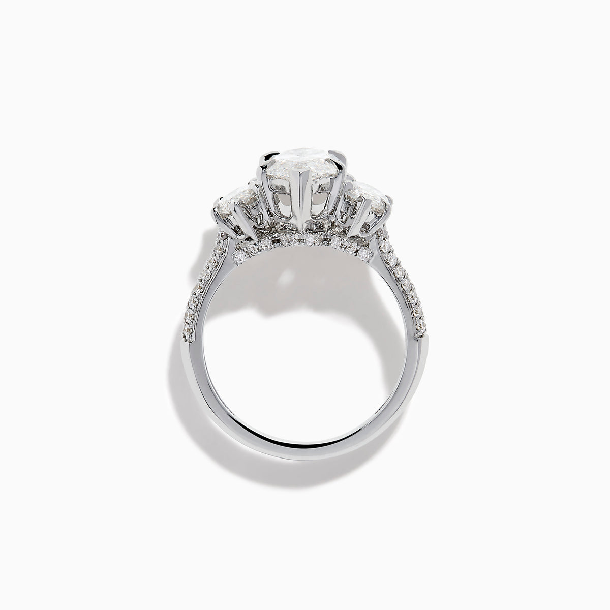 The Lab Grown Marquise Diamond 3 Stone Ring in 14K White Gold features a central marquise-cut lab grown diamond, two flanking marquise-cut diamonds, and two round diamonds set on a detailed band against a white background.
