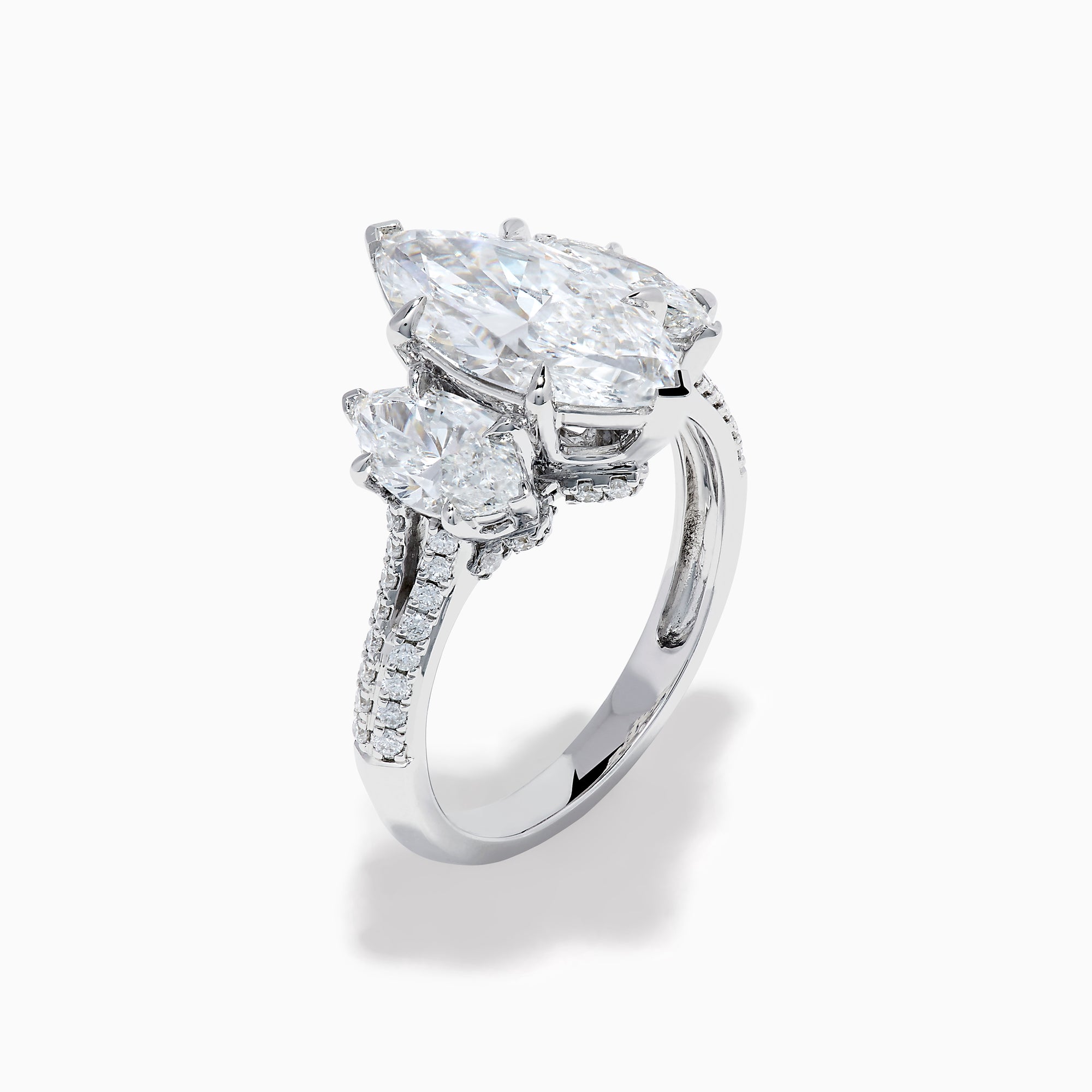 The Lab Grown Marquise Diamond 3 Stone Ring in 14K White Gold features a central marquise-cut lab grown diamond, two flanking marquise-cut diamonds, and two round diamonds set on a detailed band against a white background.